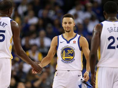 Stephen Curry #30 memberikan salam kepada rekan setimnya usai kalah dari Houston Rockets pada laga perdana NBA 2017 di Oracle Arena, Oakland, (17/10/2017).  Rockets menang 122-121. Rockets menang 122-121. (Ezra Shaw/Getty Images/AFP)