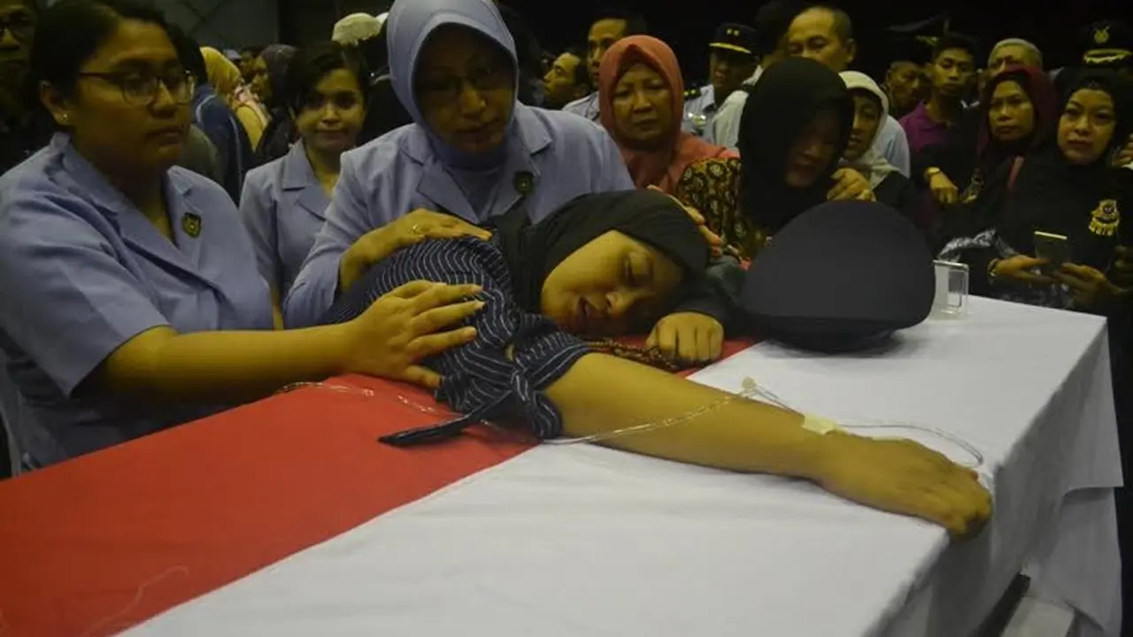 Istri korban pesawat Hercules jatuh di Wamena memeluk peti jenazah suaminya. 