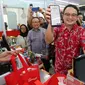 Wakil Menteri Perdagangan RI Jerry Sambuaga (tengah) didampingi Presiden Direktur OVO Karaniya Dharmasaputra (kiri) menunjukkan notifikasi pembayaran yang telah diproses usai melakukan pemindaian barcode QRIS OVO pada layar handphone pelanggan di sela Peluncuran QRIS CPM OVO di Toko Alfamart Patal Senayan, Jakarta (20/03/2023) (Liputan6.com)