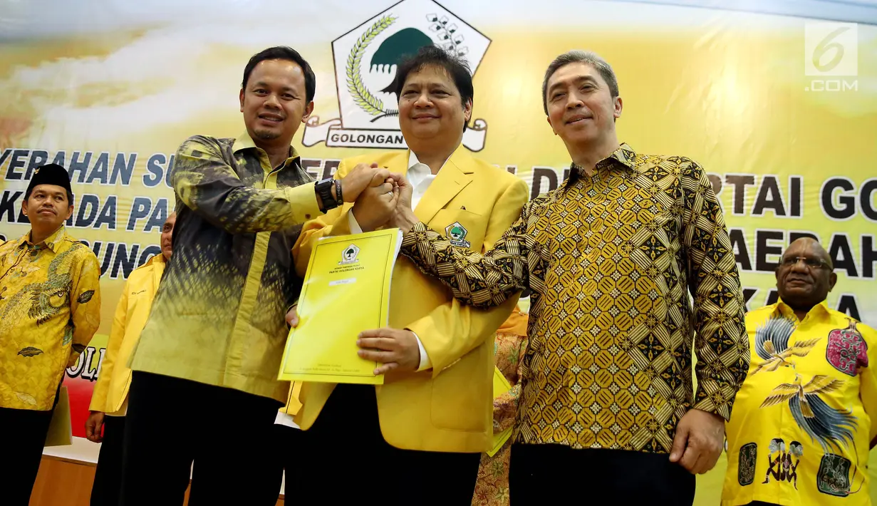 Ketum DPP Partai Golkar Airlangga Hartarto (tengah) memberikan surat rekomendasi bakal calon Walikota Bogor Bima Arya Sugiarto dan bakal calon wakil Walikota Bogor Dedie A Rachim di Kantor DPP Partai Golkar, Jakarta, Jumat (5/1). (Liputan6.com/JohanTallo)