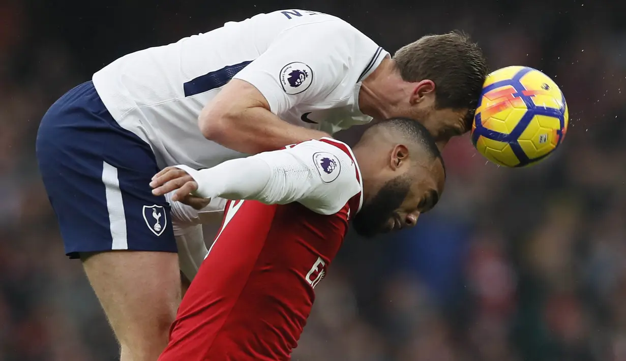 Bek Tottenham, Jan Vertonghen, duel udara dengan striker Arsenal, Alexandre Lacazette, pada laga Premier League di Stadion Emirates, London, Sabtu (18/11/2017). Arsenal menang 2-0 atas Tottenham. (AP/Kirsty Wigglesworth)
