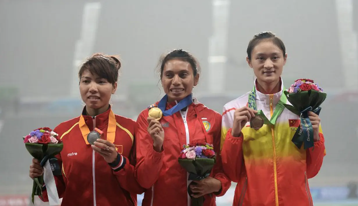 Maria Natalia Londa (tengah) berpose bersama peraih medali lainnya, Thi Thu Thao Bui (kiri) dan Jiang Yanfei di podium kemenangan di Incheon Asiad Main Staidium, Incheon, Senin (29/9). (AFP PHOTO/Manan Vatsyayana)