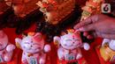 Patung kucing keberuntungan atau Maneki Neko menjadi yang paling banyak dicari saat Imlek selain angpau. (Magang/Liputan6.com/Muhammad Rizal)