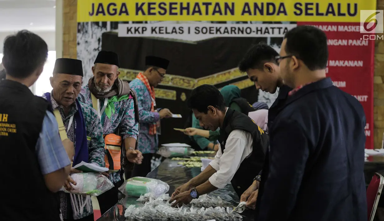 Panitia Penyelenggara Ibadah Haji (PPIH) memberikan perlengkapan untuk calon jemaah haji kloter pertama di Asrama Haji, Jakarta, Sabtu (6/7/2019). Sebelum diberangkatkan, petugas mengecek kembali 385 calon jamaah untuk melakukan kelengkapan administrasi. (Liputan6.com/Faizal Fanani)