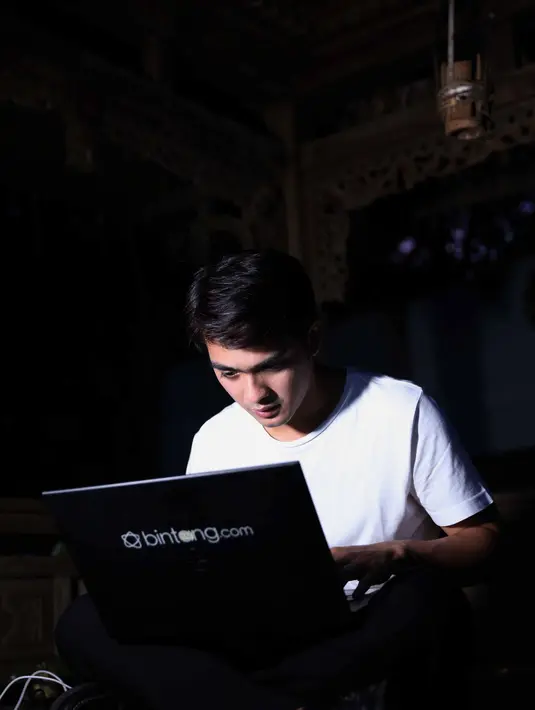 Saking sibuknya menjawab pertanyaan dari para penggemarnya, Kirun, lelaki ini biasa disapa selain sibuk membawa dan menjawab pertanyaan, ia juga sibuk mengusir nyamuk yang menghampirinya. (Nurwahyunan/Bintang.com)