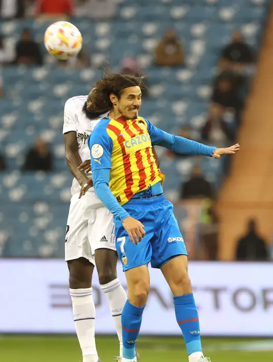 Bek Real Madrid, Antonio Rudiger berebut bola dengan penyerang Valencia, Edinson Cavani selama pertandingan semifinal Piala Super Spanyol di Stadion Internasional King Fahd di Riyadh, Arab Saudi, Kamis (12/1/2023). Real Madrid menang adu penalti 4-3 (1-1) atas Valencia. (AFP/Fayez Nureldine)