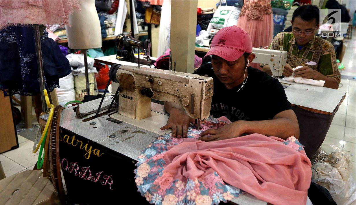 Seorang penjahit menjahit baju di Pasar Mayestik, Jakarta Selatan, Senin (11/6). Masyarakat mulai membeli dan membuat baju pilihan mereka jelang Lebaran. (Liputan6.com/JohanTallo)