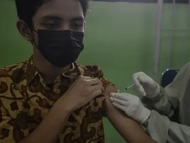 Seorang siswa menjalani vaksin COVID-19 di SMUN 20 Jakarta, Kamis (1/7/2021). Per tanggal 1 Juli 2021, anak-anak usia 12-17 tahun di DKI Jakarta sudah mulai mendapatkan vaksinasi. Agar anak-anak kita terlindungi dari wabah Covid-19 dengan varian baru. (merdeka.com/Imam Buhori)