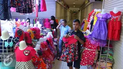 Penjaga toko merapikan baju di Pasar Tanah Abang, Jakarta, Jumat (15/7). Libur Lebaran telah selesai, namun kawasan Blok B Pasar Tanah Abang masih sepi. (Liputan6.com/Angga Yuniar)