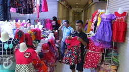 Penjaga toko merapikan baju di Pasar Tanah Abang, Jakarta, Jumat (15/7). Libur Lebaran telah selesai, namun kawasan Blok B Pasar Tanah Abang masih sepi. (Liputan6.com/Angga Yuniar)