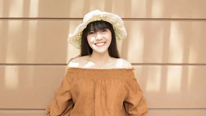 bahagia memakai topi baju coklat