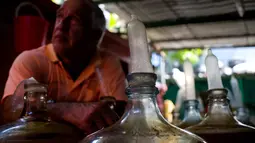 Kendi-kendi berisi racikan wine buatan Orestes Estevez Havana, Kuba, Kamis (30/3). Anggur buatan Orestes telah menjadi minuman tradisional warga El Cerro. (AP Photo)