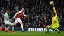 Kiper Bournemouth Artur Boruc gagal menghalau bola dari pemain Arsenal, Mesut Ozil yang menjebol gawangnya pada laga lanjutan Liga Inggris, 2018-19 pekan ke-28 di Emirates Stadium, Rabu (27/2). Arsenal menang dengan skor telak 5-1. (Ian KINGTON/AFP)