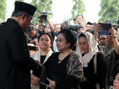 Presiden ke-6 RI Susilo Bambang Yudhoyono bersalaman dengan Presiden ke-5 RI Megawati Soekarnoputri usai prosesi pemakaman Ani Yudhoyono di TMP Kalibata, Jakarta, Minggu (2/6/2019). SBY mengucapkan terima kasih kepada Megawati yang menghadiri prosesi pemakaman Ani Yudhoyono. (Liputan6.com/HO/Rangga)