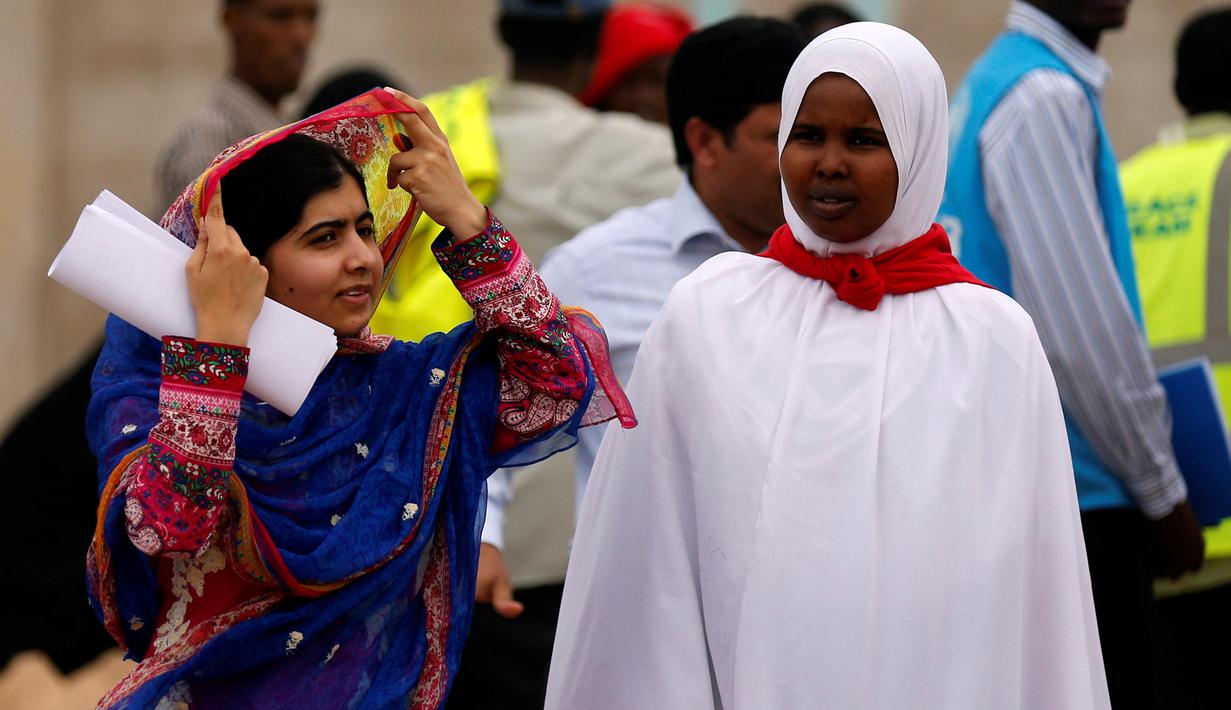 Penerima Nobel Perdamaian, Malala Yousafzai bersama salah satu pengungsi Somalia Rahma Noor saat melakukan kunjungan di kamp pengungsian Dadaab, dekat perbatasan antara Kenya-Somalia, (12/7). (REUTERS/Thomas Mukoya)