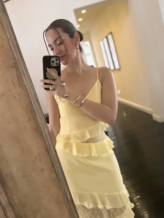 Dress kuning tersebut memiliki aksen renda di bagian pinggang dan rok. Dress semakin menarik dengan hiasan lacenya. Nia juga terlihat mengenakan berbagai aksesori seperti anting emas dan beberapa gelang.[@ramadhaniabakrie]