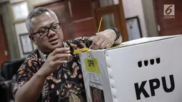 Ketua Komisi Pemilihan Umum (KPU) Arief Budiman menunjukkan kotak suara Pemilu 2019 di kantornya, Jakarta, Kamis (16/11). Arief mengatakan kotak berbahan karton kedap dengan satu sisi transparan ini juga kuat bila diberi beban (Liputan6.com/Faizal Fanani)
