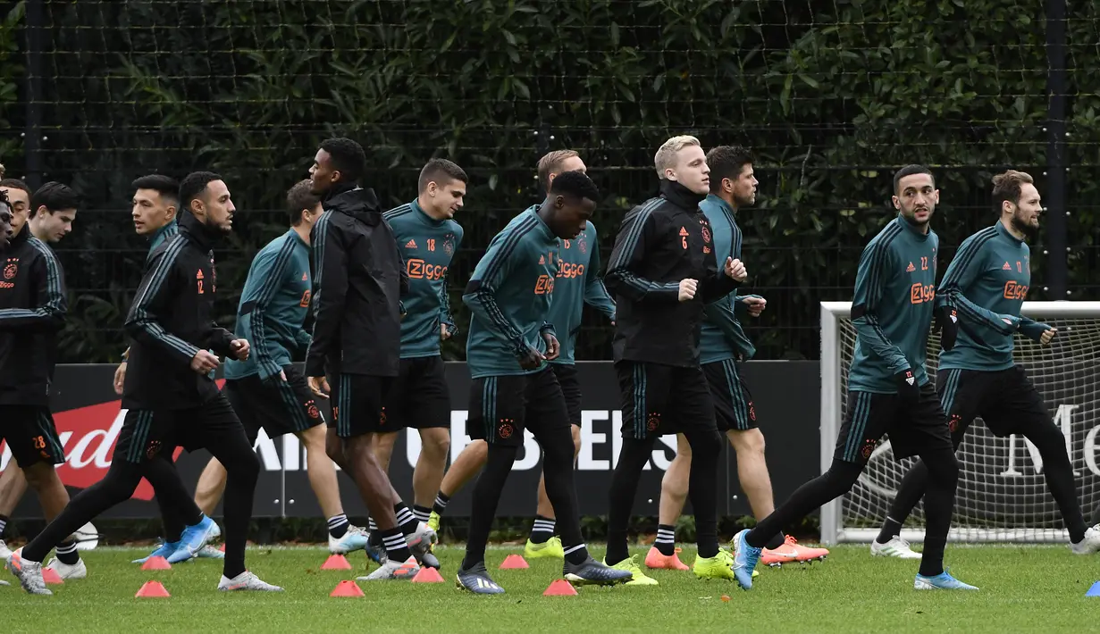Para pemain Ajax melakukan pemanasan selama sesi latihan di Amsterdam (22/10/2019). Ajax akan bertanding melawan wakil Inggris, Chelsea pada Grup H Liga Champions di Johan Cruijff Arena. (AFP Photo/John Thys)