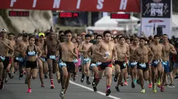 Peserta berlari dengan bertelanjang dada saat berpartisipasi pada The "Underpants Run" di Manila, Filipina, 8 April 2018. Kegiatan berkonsep fun run dengan pakaian dalam ini dimulai ketika matahari terbit. (NOEL CELIS / AFP)