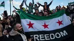 Seorang demonstran memegang bendera oposisi Suriah saat anggota komunitas Suriah meneriakkan slogan-slogan di alun-alun Syntagma, Athena untuk merayakan berakhirnya rezim Bashar al-Assad pada tanggal 8 Desember 2024. (Angelos TZORTZINIS/AFP)