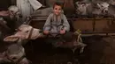 Seorang anak duduk dekat hewan ternak menjelang Idul Adha di pasar Ashmun, Mesir, Rabu (15/8). Dalam Perayaan Idul Adha, umat islam di seluruh dunia akan menyembelih hewan ternak seperti kambing, domba, onta, sapi dan kerbau. (AFP/Mohamed el-Shahed)
