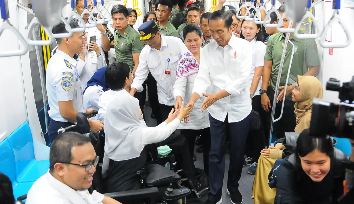 Presiden Joko Widodo didampingi Ibu Negara Iriana Widodo bersalaman dengan penyandang disabilitas saat menjajal MRT di Jakarta, Kamis (21/3). (Liputan6.com/Angga Yuniar)