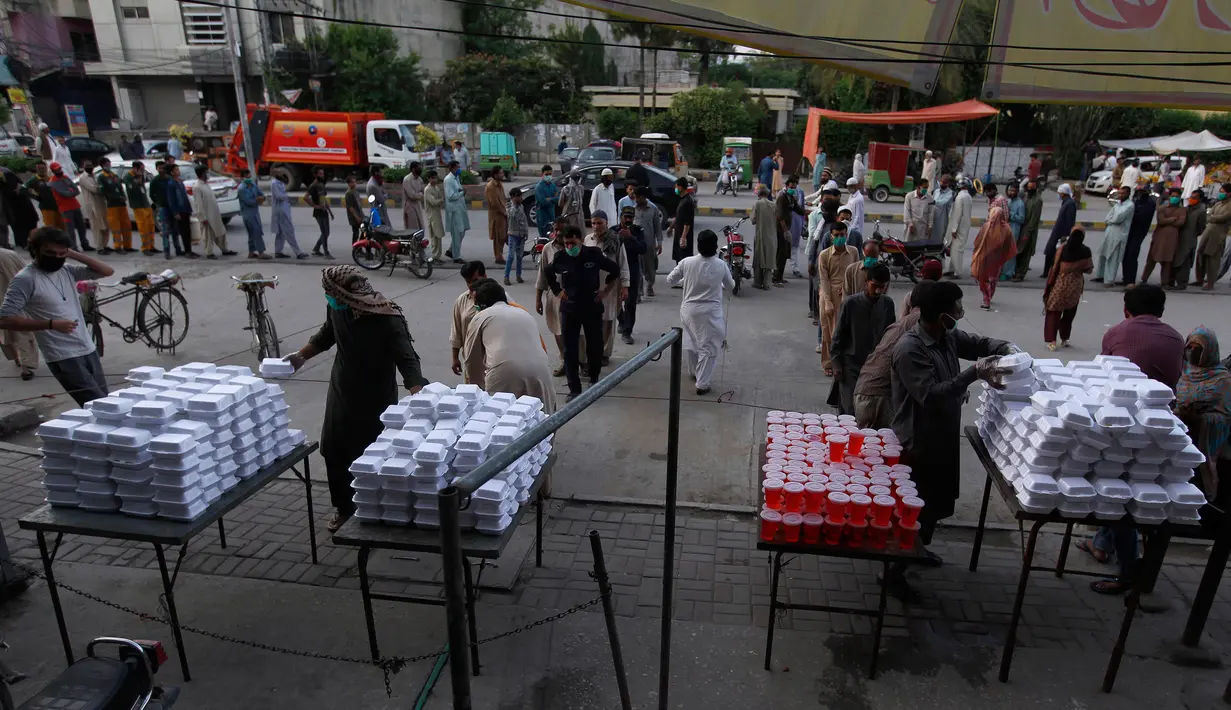 Relawan menyiapkan kotak makanan dan minuman manis tradisional untuk orang-orang berbuka puasa, di Rawalpindi, Pakistan, Minggu, (3/5/2020). Umat Muslim di seluruh dunia sedang melaksanakan Ramadan untuk menahan diri dari makan, minum sejak subuh sampai senja. (AP/Anjum Naveed)