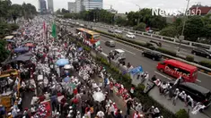 Penumpang bus Transjakarta yang terjebak macet karena aksi 212 di depan gedung DPR/MPR RI, terpaksa berjalan kaki melanjutkan perjalanan