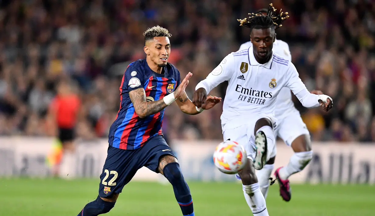 Gelandang Real Madrid, Eduardo Camavinga (kanan) menguasai bola di depan striker Bracelona, Raphinha pada laga leg kedua semifinal Copa del Rey 2022/2023 di Camp Nou Stadium, Barcelona (5/4/2023). Eduardo Camavinga baru memasuki musim kedua bersama Real Madrid sejak didatangkan pada awal musim 2021/2022. Hingga kini ia telah tampil dalam 90 laga di semua ajang bareng Los Blancos dengan torehan 2 gol dan 3 assist. (AFP/Pau Barrena)