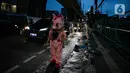 Warkuatno (41) bersama anak sulungnya, Bunga (9) berjalan kaki di pinggir Jalan Raya Fatmawati, Cilandak, Jakarta, Rabu (6/1/2021). Pandemi Covid-19 benar-benar memukulnya. Warkuatno harus memutar otak demi bisa bertahan hidup usai kehilangan pekerjaannya. (Liputan6.com/Faizal Fanani)