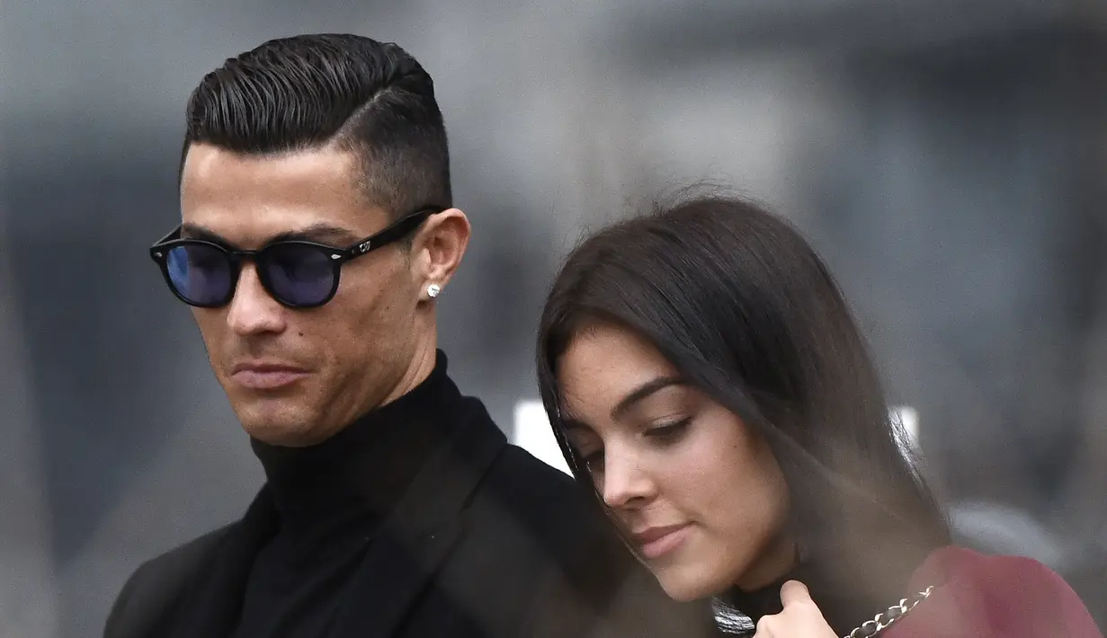 Cristiano Ronaldo bersama Georgina Rodriguez setelah menghadiri sidang pengadilan untuk penggelapan pajak di Madrid pada 22 Januari 2019. Dalam unggahan itu, Ronaldo mengungkap bahwa salah seorang dari bayi kembarnya selamat. Bayi itu berjenis kelamin perempuan. (AFP/OSCAR DEL POZO)