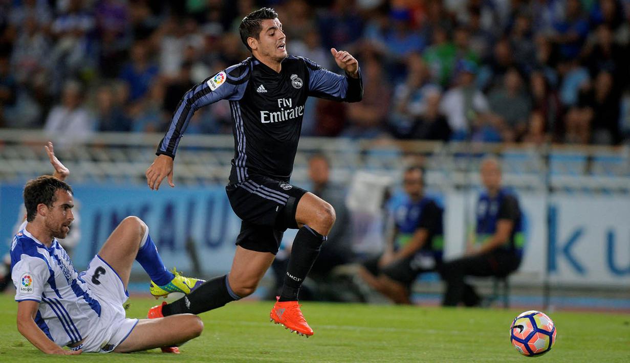 Striker Real Madrid, Alvaro Morata, berhasil melewati penjagaan pemain Real Sociedad, Mikel Gonzalez. Laga ini merupakan debut kembalinya Morata ke La Liga, setelah sebelumnya sempat  bermain bersama Juventus. (Reuters/Vincent West)