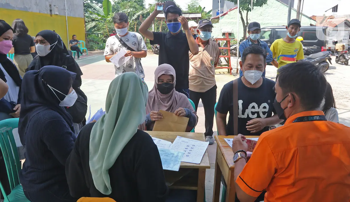 Petugas melayani warga penerima bantuan sosial tunai (BST) dari Kemensos di kawasan Kelurahan Kembangan, Meruya, Jakarta Barat, Minggu (25/07/2021). Penyaluran BST tersebut diperkirakan akan rampung pada 7 Agustus 2021 mendatang. (Liputan6.com/Herman Zakharia)