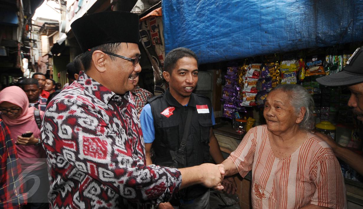 Cawagub petahana, Djarot Syaiful Hidayat menyalami warga saat sosialisasi di kawasan Pademangan VIII, Jakarta, Kamis (23/3). Selain sosialisasi dengan warga, Djarot juga menyerap keluhan warga sekitar. (Liputan6.com/Helmi Fithriansyah)  