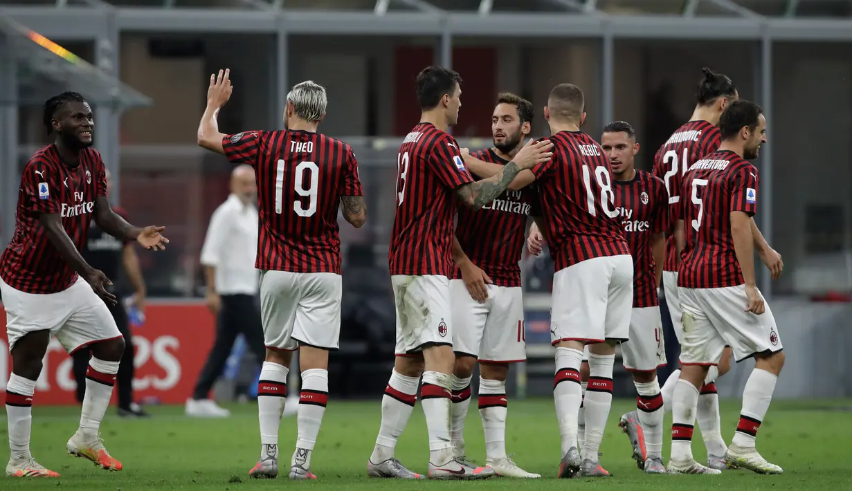 Gelandang AC Milan, Hakan Calhanoglu (tengah) berselebrasi dengan rekan-rekannya usai mencetak gol ke gawang Parma pada pertandingan lanjutan Liga Serie A Italia di Stadion San Siro di Milan, Italia (15/7/2020). AC Milan menang telak 3-1 atas Parma. (AP Photo/Luca Bruno)