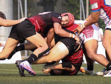 Sejumlah pemain tim rugby putra Singapura (kiri) berebut bola dengan pemain tim rugby putra Indonesia saat laga Asia Rugby Sevens Trophy 2022 yang berlangsung di GBK Rugby Field, Jakarta, Sabtu (06/08/2022). (Bola.com/Bagaskara Lazuardi)