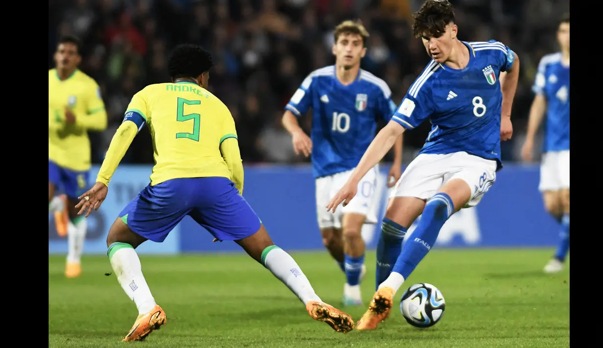 Pemain Timnas Italia U-20, Cesare Casadei (kanan), berusaha melewati hadangan pemain Timnas Brasil U-20, Andrey Santos (kiri) dalam pertandingan Grup D Piala Dunia U-20 2023 yang berlangsung di Malvinas Argentinas stadium, Argentina, Minggu (21/5/2023). Casedei yang dipinjamkan Chelsea ke Reading pada musim 2022/2023 telah mendulang enam gol dan satu assist dalam 28 laga yang ia mainkan di semua kompetisi. (AFP/Andres Larrovere)