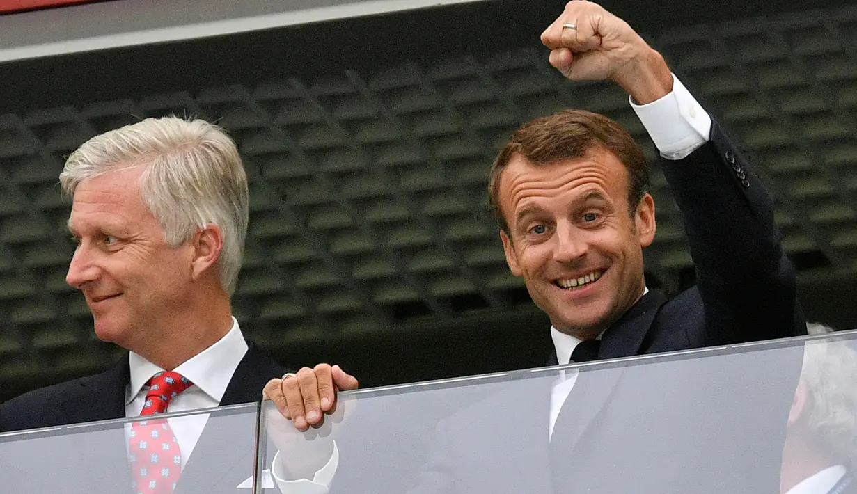 Presiden Prancis, Emmanuel Macron di samping Raja Belgia Philippe mengepalkan tangan ke udara saat menyaksikan laga semifinal Piala Dunia 2018 di St Petersburg Stadium, Selasa (10/7). Prancis sukses mengamankan satu tiket final. (AP/Martin Meissner)