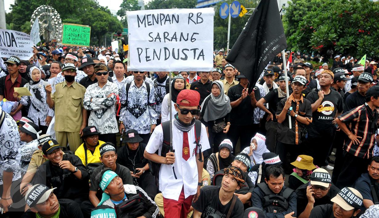 Seorang pengunjuk rasa mengenakan seragam sekolah SD saat menggelar aksi unjuk rasa di depan Istana Merdeka, Jakarta, Rabu (10/2). Guru honorer dari seluruh Indonesia itu menuntut Pemerintah agar mengangkat mereka sebagai PNS (Liputan6.com/Gempur M Surya)