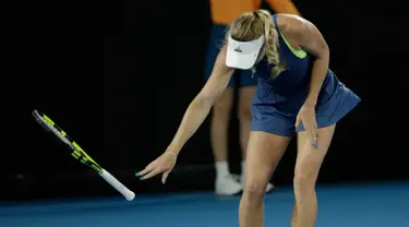 Petenis Denmark, Caroline Wozniacki melempar raketnya ketika melawan petenis Belanda, Kiki Bertend di babak ketiga Australia Terbuka 2018, Jumat (19/1). Wozniacki kecewa dengan keputusan wasit yang membuatnya kehilangan satu poin. (AP/Dita Alangkara)