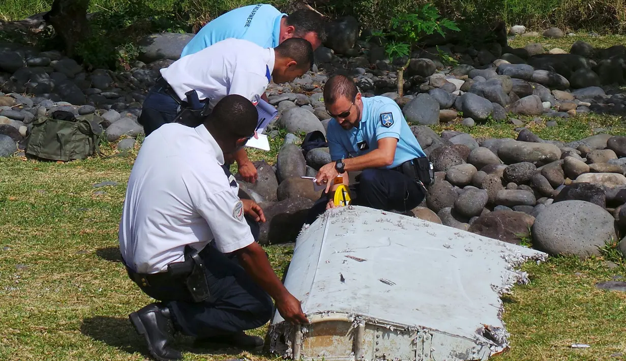 Polisi memeriksa potongan besi mirip badan pesawat yang diduga milik MH370 di pantai Saint - Andre, Perancis, Rabu (29/30/2015).  Puing sepanjang dua meter itu tampak mirip bagian dari sayap  pesawat. (REUTERS/Prisca Bigot)