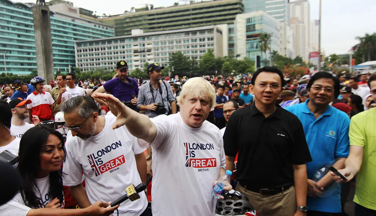 Walikota London, Boris Johnson (tengah) berbincang dengan Gubernur DKI Jakarta, Basuki Tjahaja Purnama (berkaos hitam) di kawasan Bundaran HI Jakarta, Minggu (30/11/2014). (Liputan6.com/Faizal Fanani)