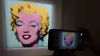 Jurnalis mengambil foto lukisan "Shot Sage Blue Marilyn" karya Andy Warhol selama pratinjau pers di New York, Senin (21/3/2022).  Rumah lelang Christie menyatakan akan melelang lukisan potret Marilyn Monroe yang dibuat Warhol pada 1964 tersebut pada Mei mendatang di New York. (TIMOTHY A. CLARY/AFP)