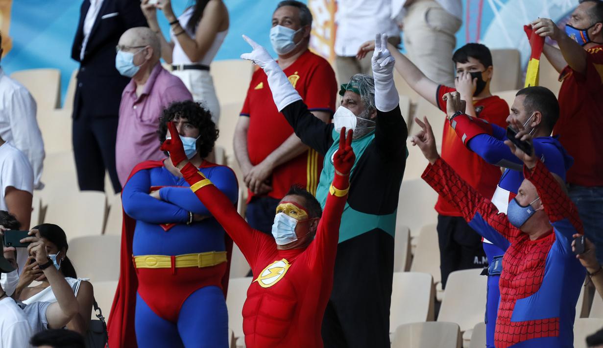 Suporter Spanyol berpakaian adu banteng, mengibarkan bendera negaranya di luar arena adu banteng Plaza de Toros, di Seville, Spanyol, Sabtu, 19 Juni 2021. Spanyol akan menghadapi Polandia pada Sabtu malam di Grup E Euro 2020. (Foto: AP/Pool/Thanassis Stavrakis)