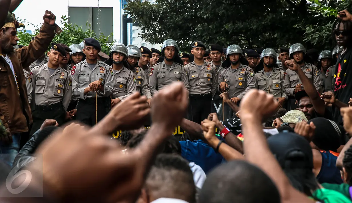 Polisi anti huru hara menjaga aksi ratusan orang Papua yang berdomisili di Jawa dan Bali saat peringatan 1 Desember di Bundaran HI, Jakarta, Selasa (1/12). Tanggal 1 Desember juga diartikan sebagai hari kemerdekaan Papua. (Liputan6.com/Faizal Fanani)