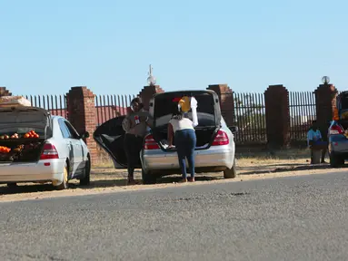 Orang-orang menjual berbagai barang di dalam bagasi mobil di sisi jalan yang sibuk di Harare, 1 Juli 2020. Mobil menjadi pasar bergerak di mana penduduk Zimbabwe menjual barang dagangan dari kendaraan untuk mengatasi kesulitan ekonomi yang disebabkan Covid-19. (AP Photo/Tsvangirayi Mukwazhi)