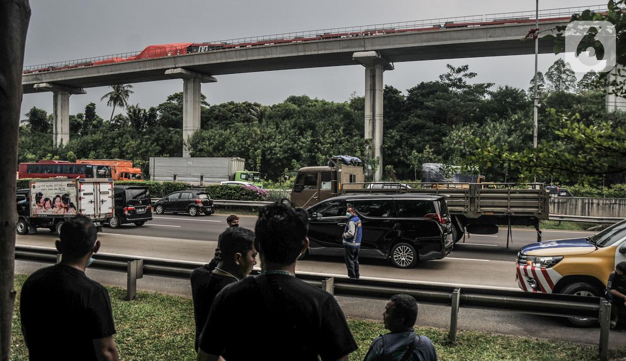 Warga menyaksikan kondisi rangkaian kereta Light Rail Transit (LRT) Jabodebek usai kecelakaan di kawasan Munjul, Cibubur, Jakarta, Senin (25/10/2021). Belum diketahui penyebab tabrakan tersebut dan hingga kini petugas masih menjaga di area kecelakaan. (merdeka.com/Iqbal S Nugroho)
