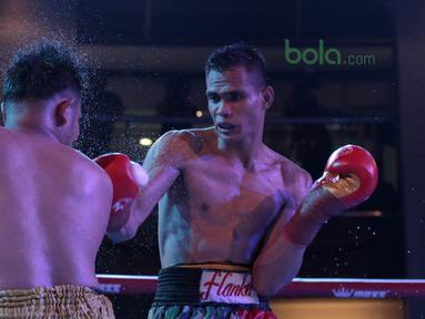 Ilham Leoisa (kanan) memukul di wajah petinju Thailand, Paiboon Lorkham pada kelas Super-Lightweight Mahkota Boxing Super Series di Cilandak Town Square, Jakarta (10/3/2018). Ilham menang angka mutlak. (Bola.com/Nick Hanoatubun)
