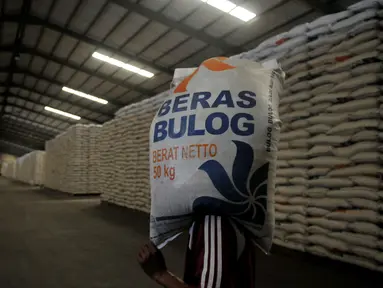 Pekerja memanggul karung Beras milik Badan Urusan Logistik (Bulog) di Gudang Bulog kawasan Kelapa Gading, Jakarta Utara, Selasa (7/6). Bulog memiliki stok beras sebanyak 2,1 juta ton. (Liputan6.com/Johan Tallo)