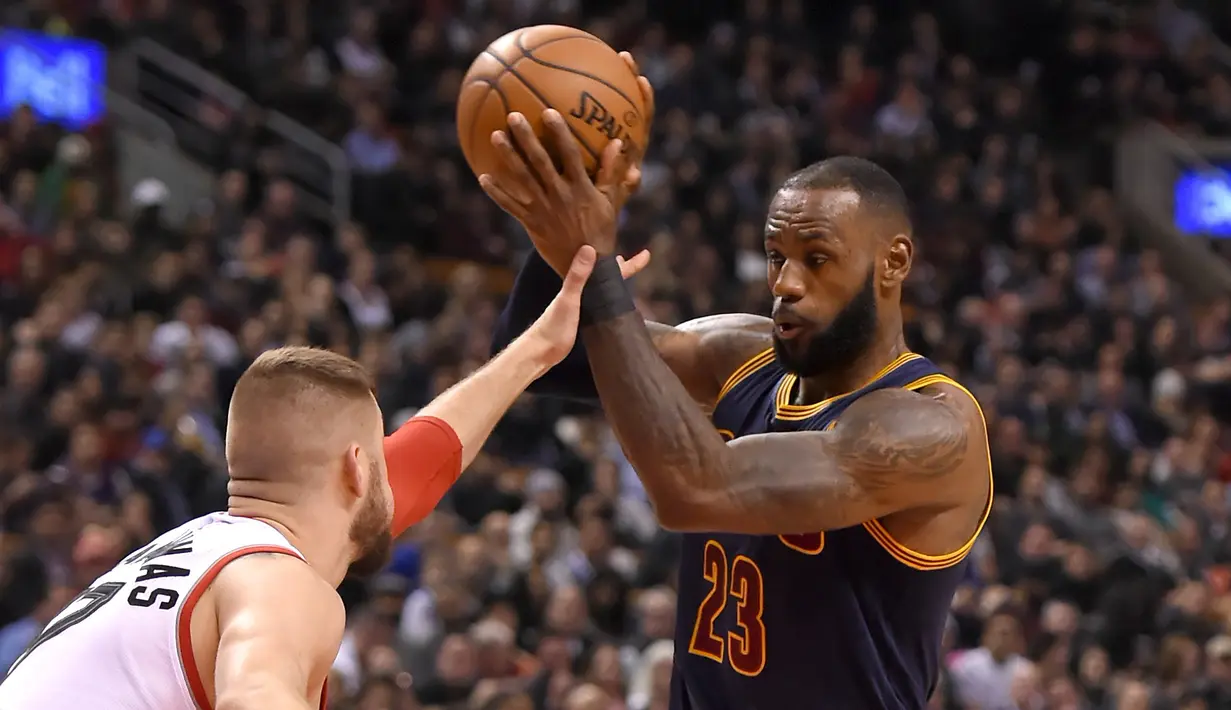 Pemain Cleveland Cavaliers, LeBron James #23 berusaha melewati hadangan pemain Raptors, Jonas Valanciunas #17 pada laga NBA di Air Canada Centre, (6/12/2016). (Reuters/Dan Hamilton-USA TODAY Sports)